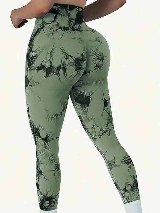 Green leggings with black abstract pattern worn by a person on a white background